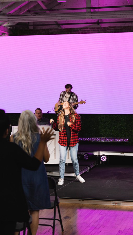 A singer and a guitarist on stage against a wall of magenta light