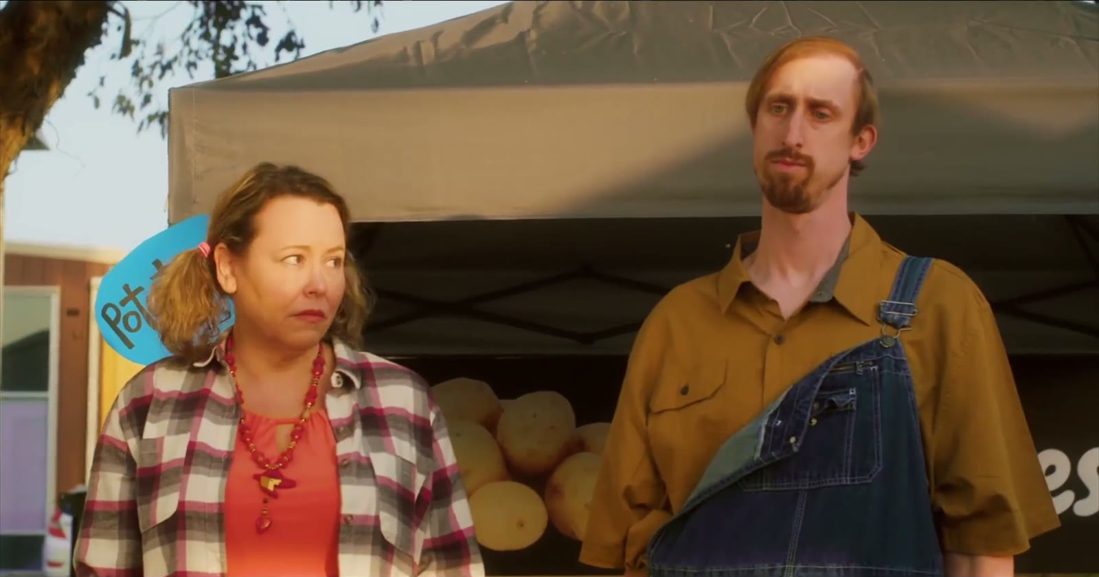 Tabitha and Leo standing at their roadside potato stand